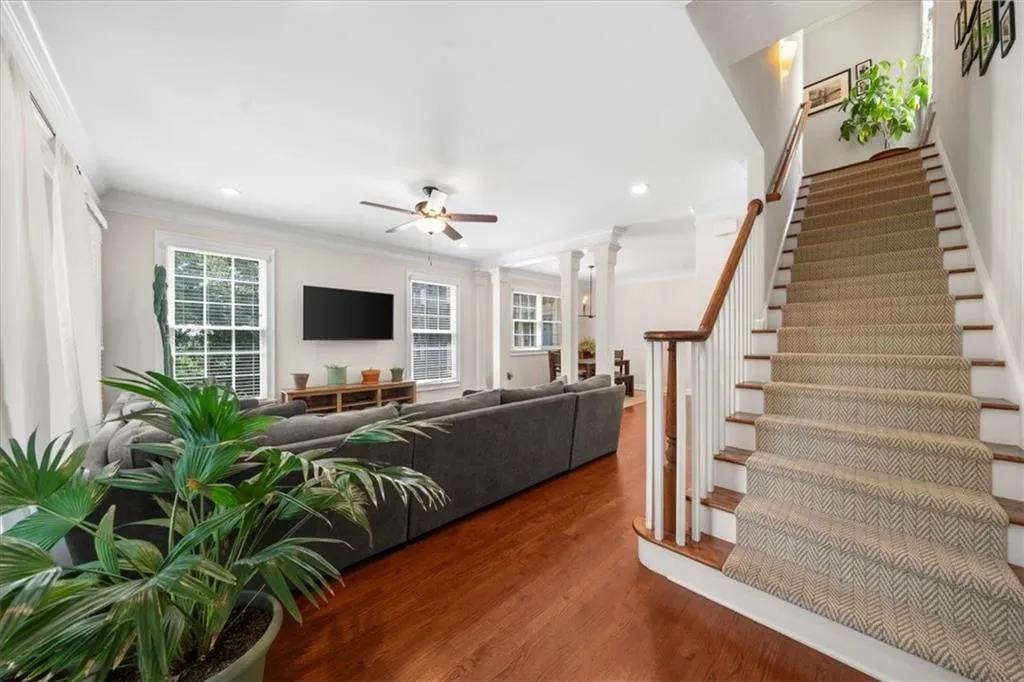 Stairs featuring crown molding, ceiling fan, wood finished floors, ornate columns, and recessed lighting