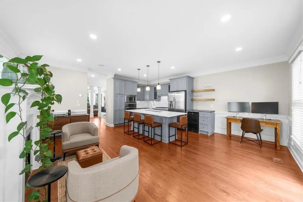 Living room with light wood-style flooring, recessed lighting, and ornamental molding