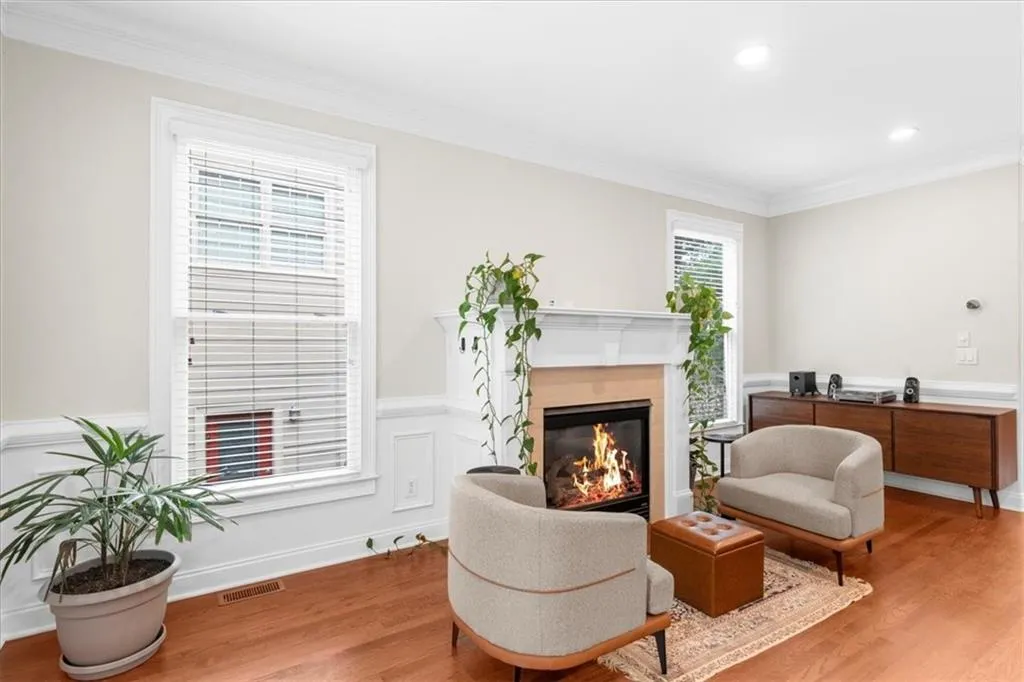 Living area with wood finished floors, a high end fireplace, ornamental molding, and recessed lighting