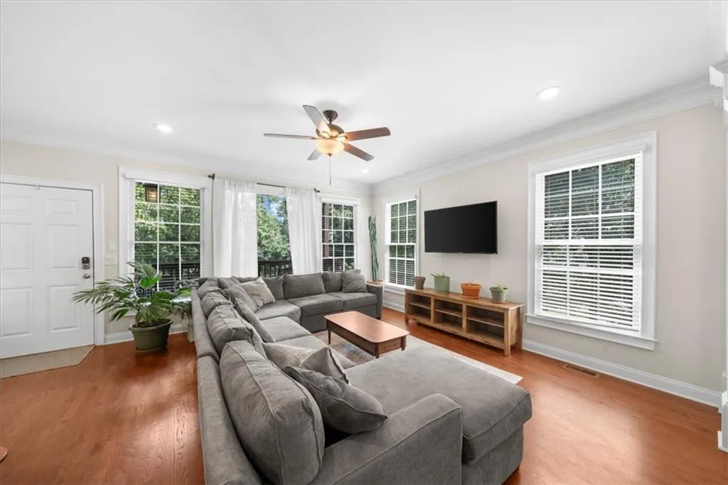 Living area with ceiling fan, ornamental molding, wood finished floors, and recessed lighting