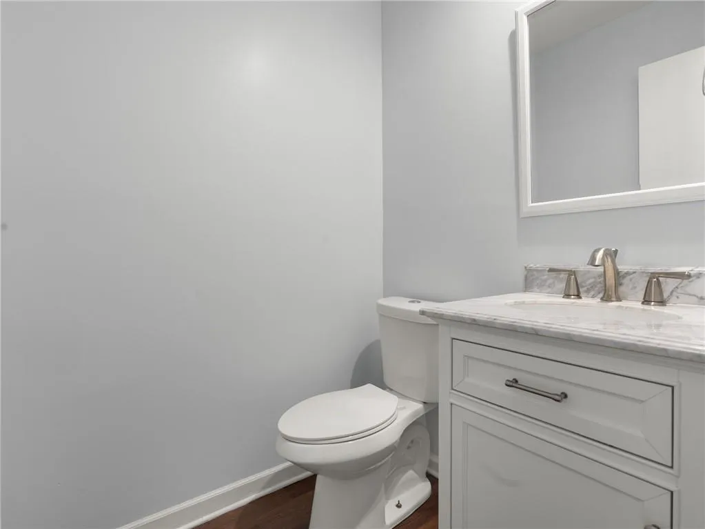 Half bathroom with vanity and wood finished floors
