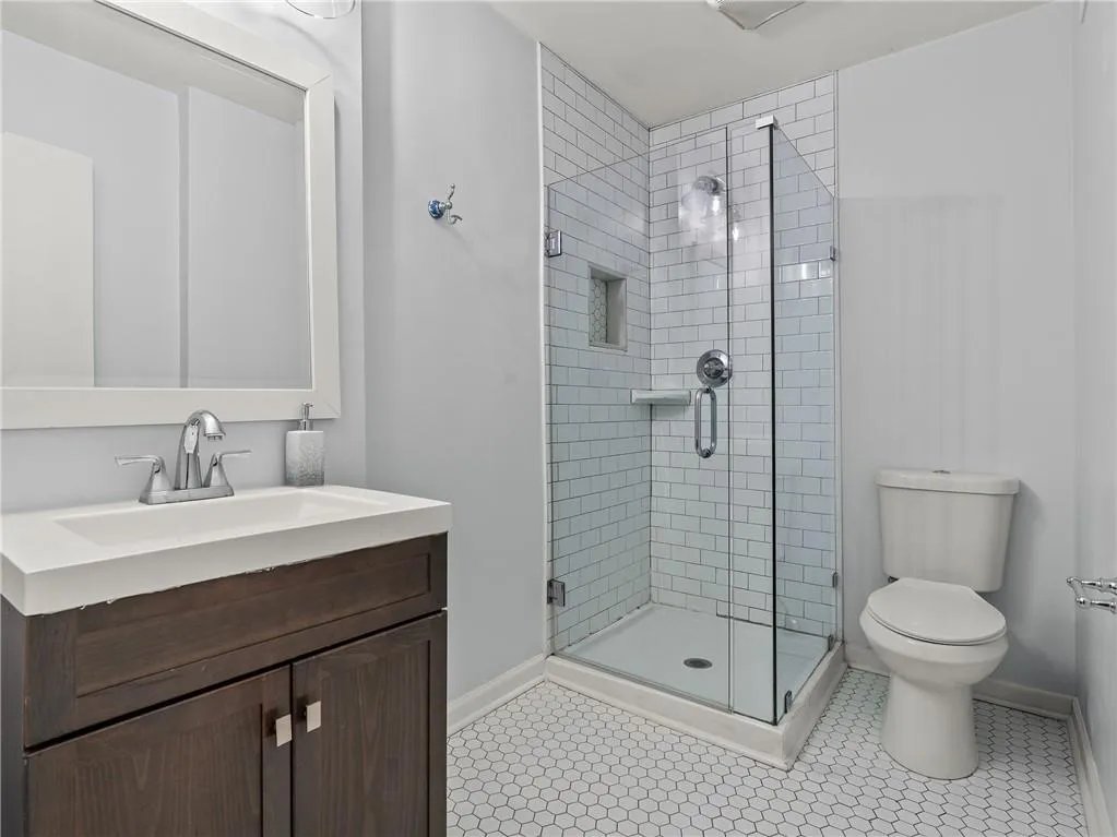 Bathroom with a stall shower, vanity, and tile patterned floors