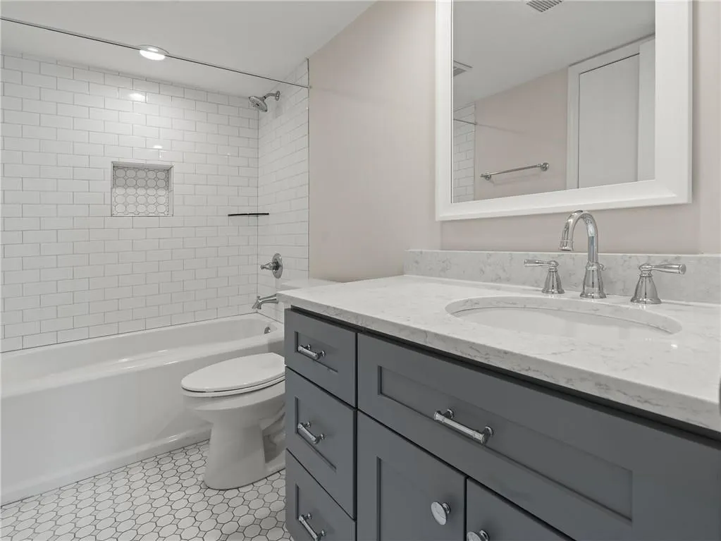 Bathroom with vanity, tub / shower combination, and tile patterned flooring
