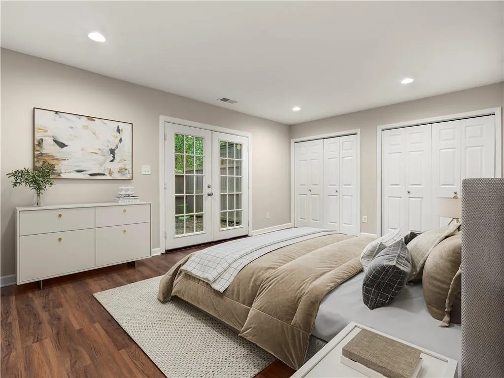 Bedroom with recessed lighting, two closets, dark wood-style flooring, access to exterior, and french doors