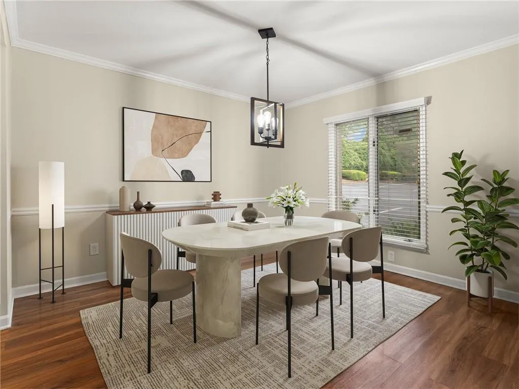 Dining area with crown molding, dark wood-style floors, and a chandelier