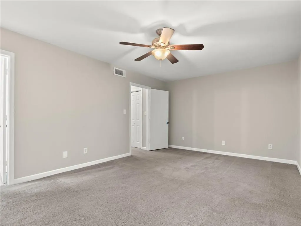 Unfurnished bedroom featuring carpet floors and a ceiling fan