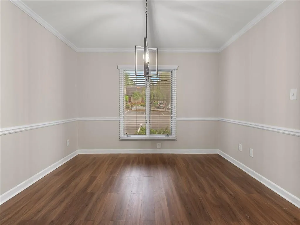 Unfurnished dining area with crown molding and wood finished floors