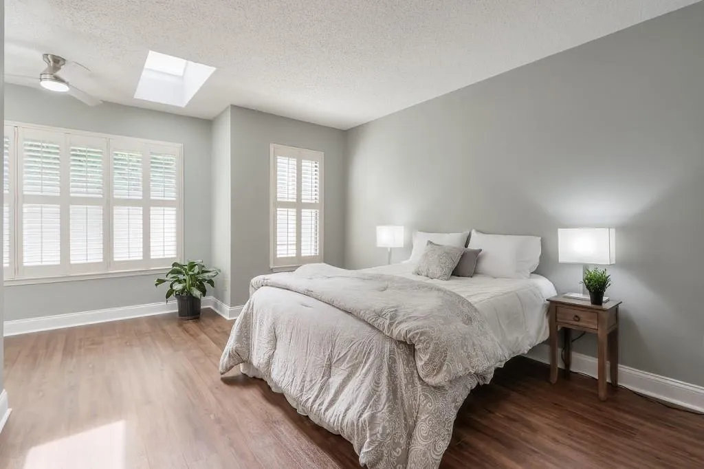 Spacious Primary Bedroom With Lots Of Natural Light Streaming Through The Upgraded Plantation Shutters