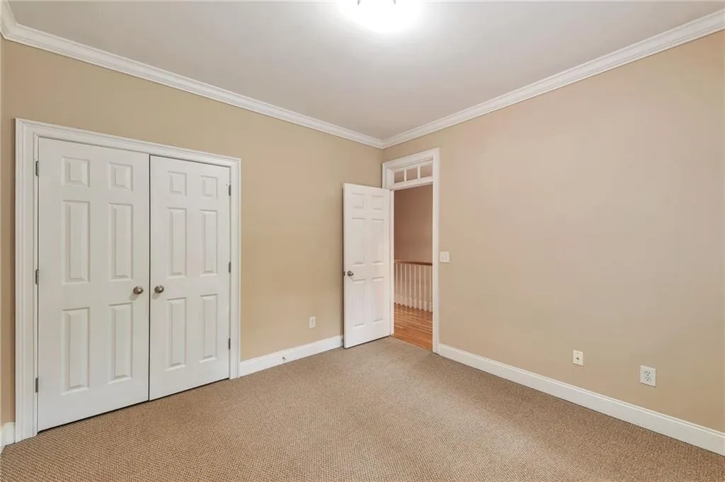 Unfurnished bedroom featuring crown molding, carpet, and a closet