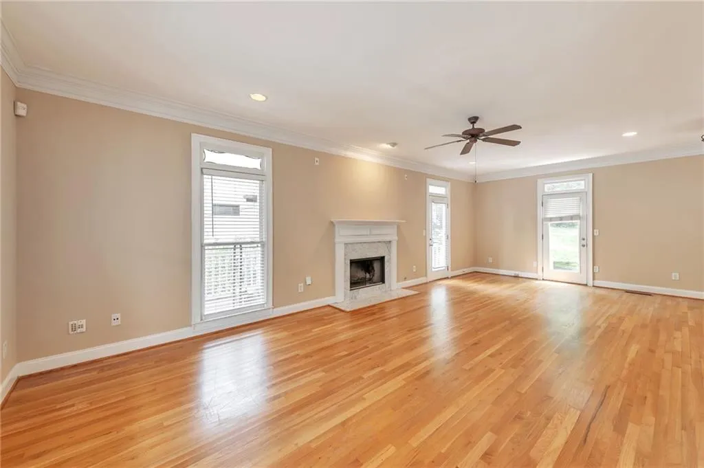 Unfurnished living room with crown molding, a premium fireplace, light wood-style floors, ceiling fan, and recessed lighting