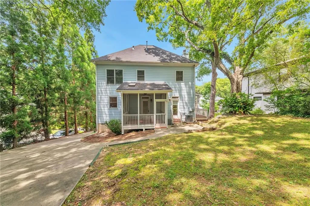 Rear view of house featuring a yard and a sunroom