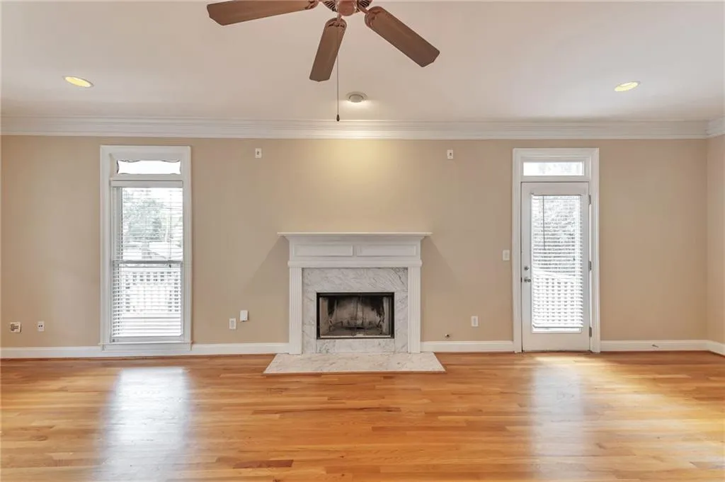 Unfurnished living room with recessed lighting, light wood-style flooring, ornamental molding, a high end fireplace, and ceiling fan