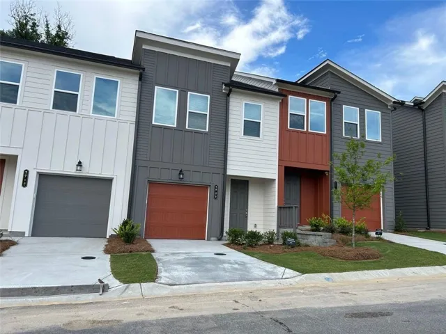 Modern exterior with multi-toned siding, attached garages, paved driveways, and manicured landscaping
