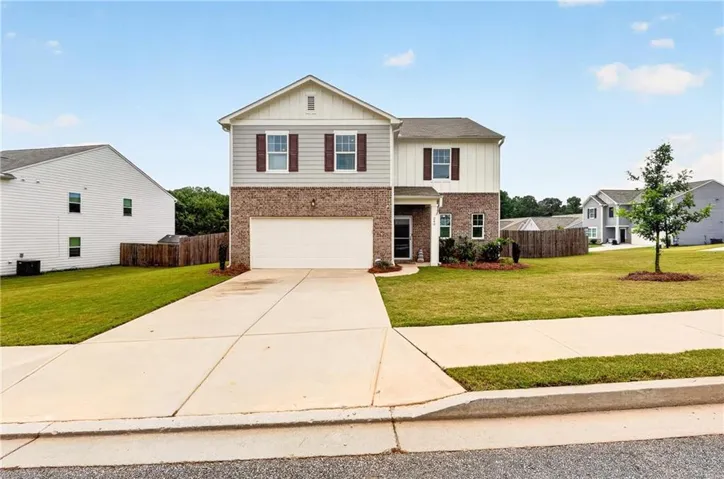 Two-story exterior with brick and siding facade, attached two-car garage, and concrete driveway