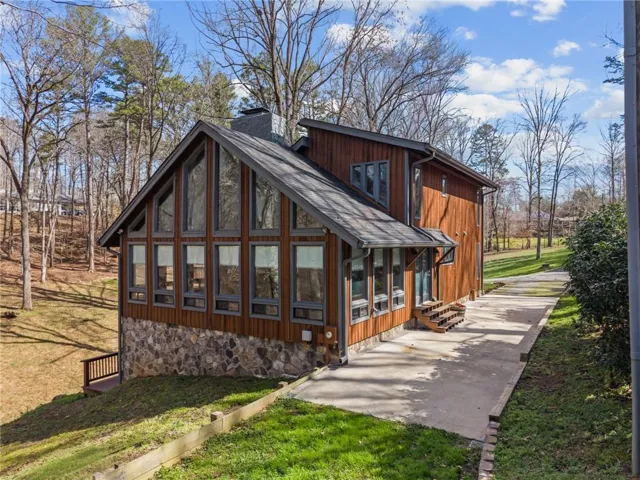 Back of property featuring a sunroom, a yard, a chimney, and entry steps