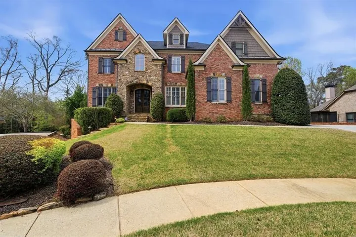 Brick and stone facade residence featuring multiple gables and dormer windows