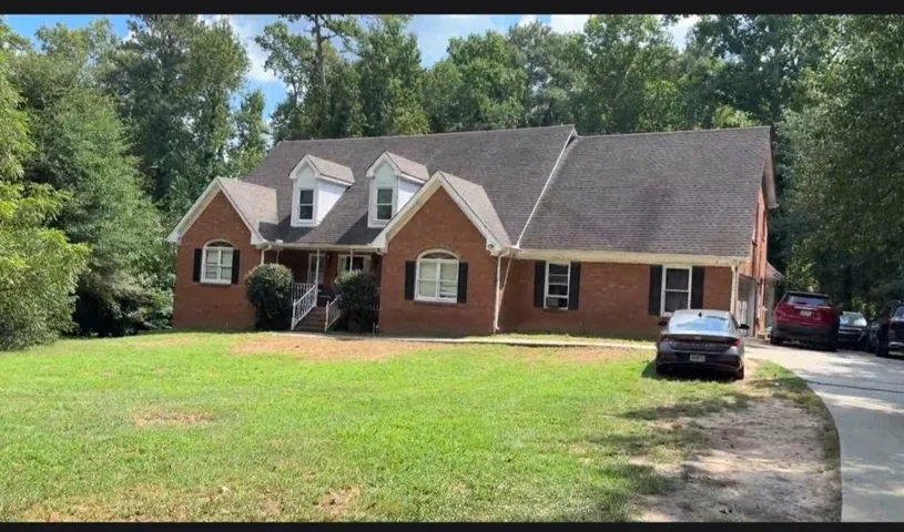 Brick exterior with multiple gables, front dormer windows, and a covered entry