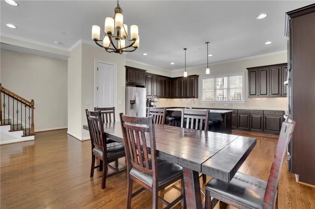 Dining room featuring baseboards, stairs, ornamental molding, wood finished floors, and an inviting chandelier Dining room featuring baseboards, stairs, ornamental molding, wood finished floors, and an inviting chandelier