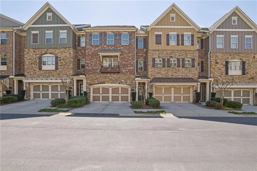 Multi unit property featuring driveway, a garage, and board and batten siding Multi unit property featuring driveway, a garage, and board and batten siding