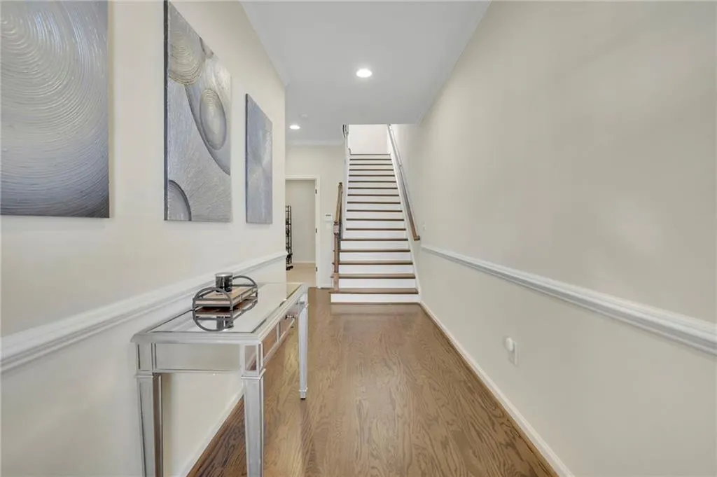 Hall featuring crown molding, baseboards, wood finished floors, stairway, and recessed lighting Hall featuring crown molding, baseboards, wood finished floors, stairway, and recessed lighting
