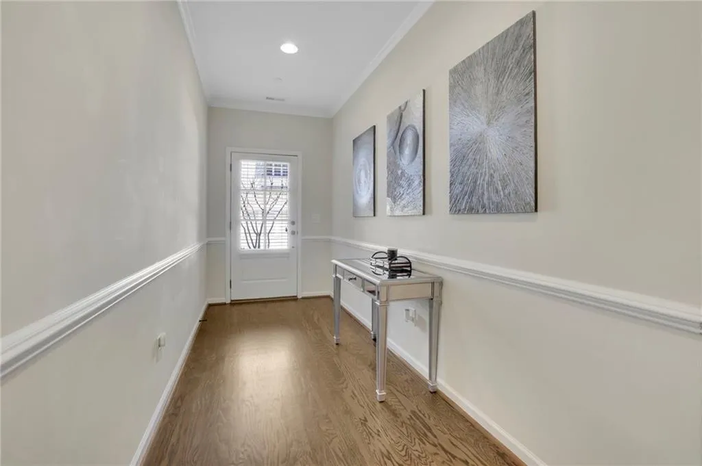 Doorway with baseboards, crown molding, wood finished floors, and recessed lighting Doorway with baseboards, crown molding, wood finished floors, and recessed lighting