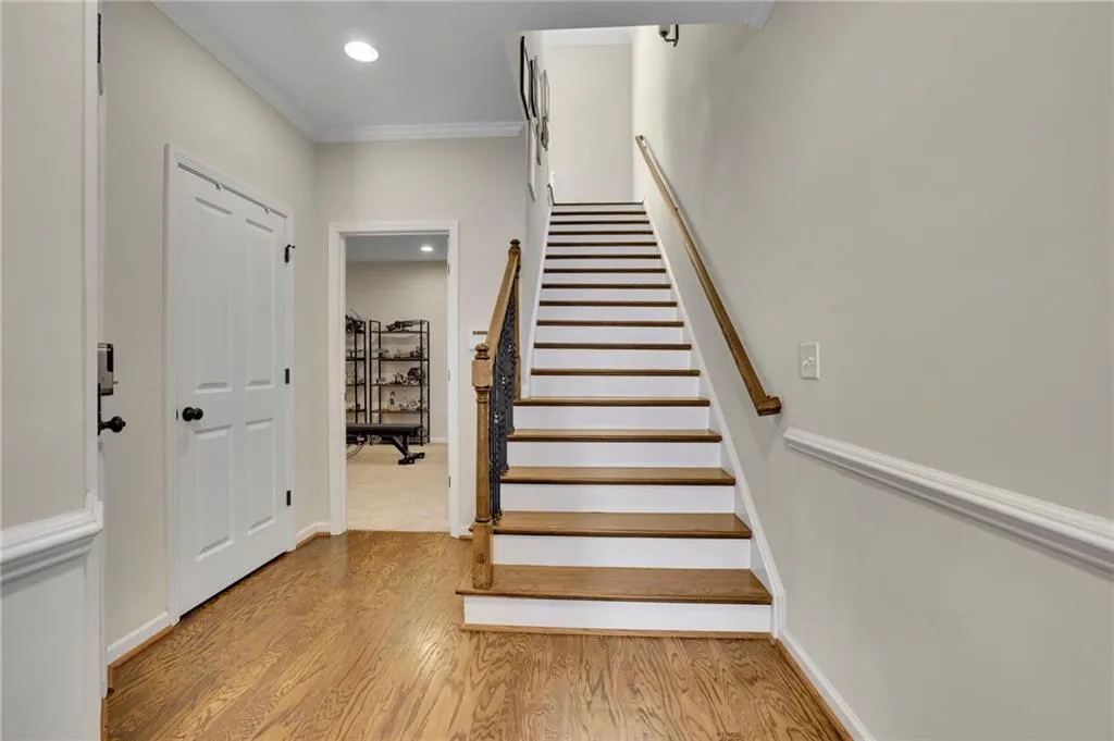 Staircase featuring recessed lighting, crown molding, baseboards, and wood finished floors Staircase featuring recessed lighting, crown molding, baseboards, and wood finished floors