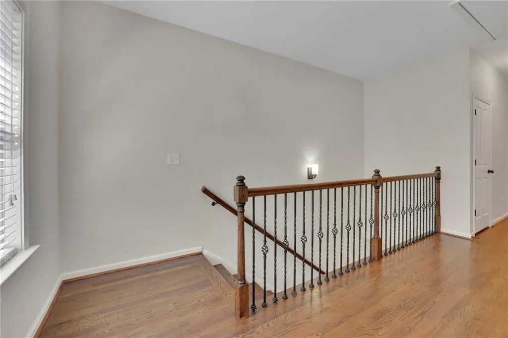 Stairs with attic access, baseboards, and wood finished floors Stairs with attic access, baseboards, and wood finished floors