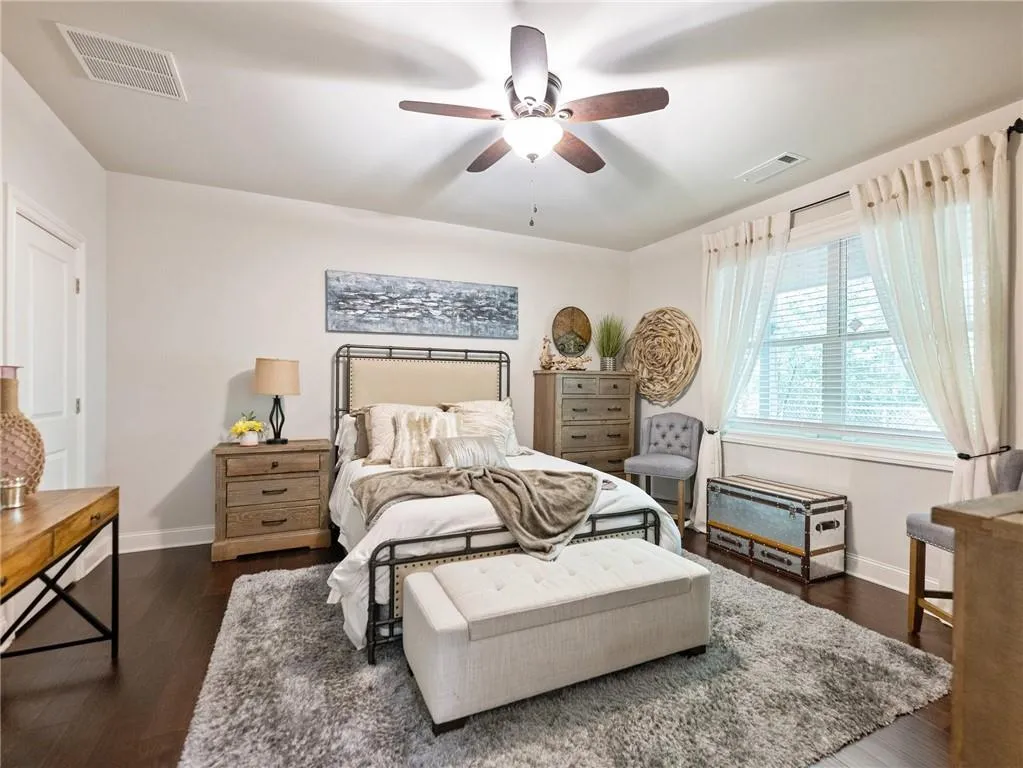 Bedroom featuring baseboards, dark wood-style flooring, and a ceiling fan