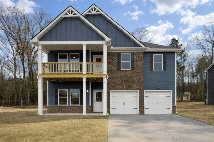 View of front of house with concrete driveway, a garage, a front lawn, and board and batten siding