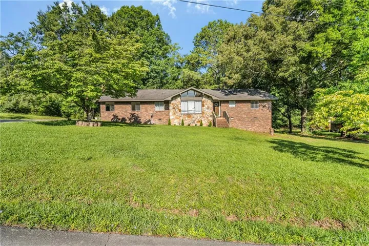 Brick exterior featuring a stone accent facade and a large front lawn