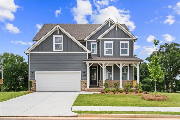 Two-story residence featuring a gray siding exterior with white trim accents and a covered front porch