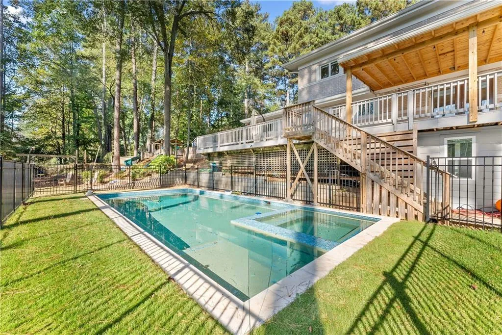 View of swimming pool featuring stairs, a patio area, a pool with connected hot tub, and a deck