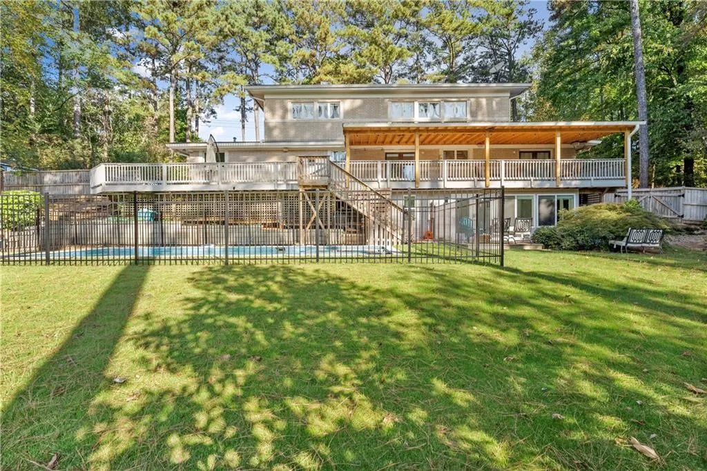 Rear view of house with stairs, a wooden deck, a patio, and view of wooded area