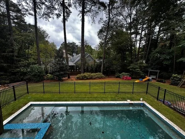 View of pool with a playground, a fenced backyard