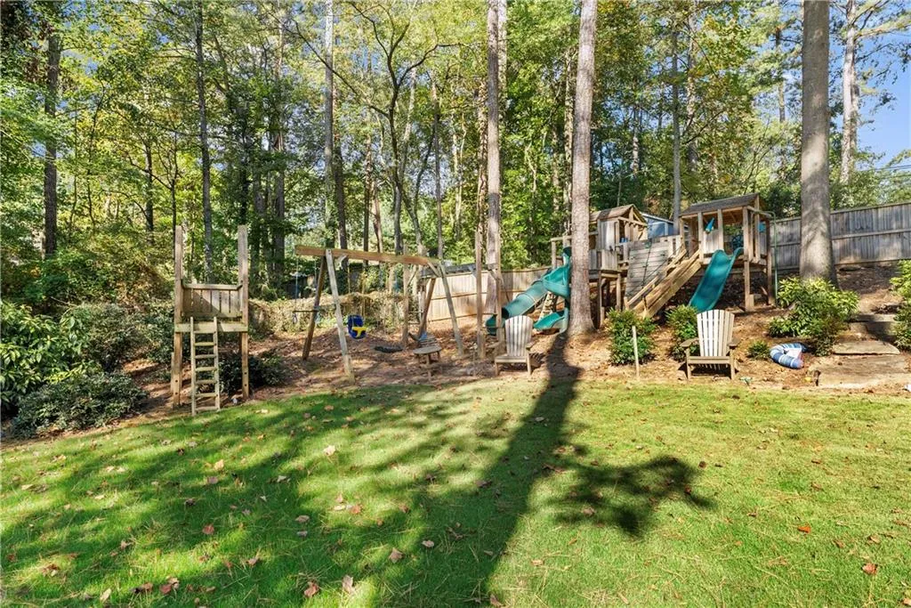 Back of house featuring a wooden deck, a fenced backyard, and stairs