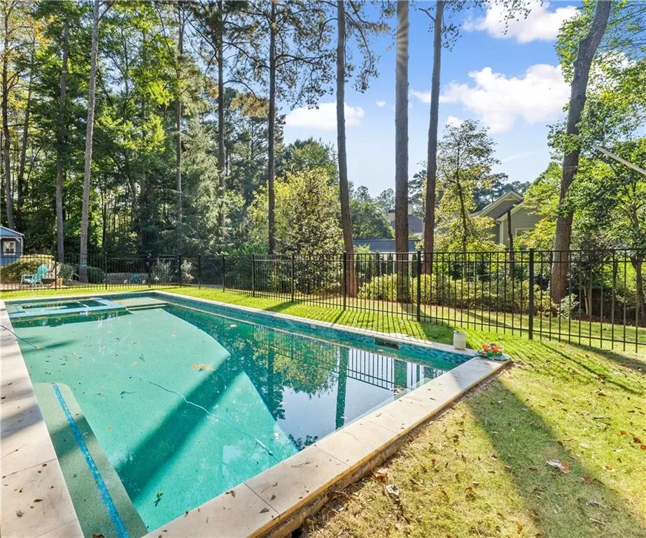View of swimming pool featuring a fenced backyard, a patio, and a pool with connected hot tub
