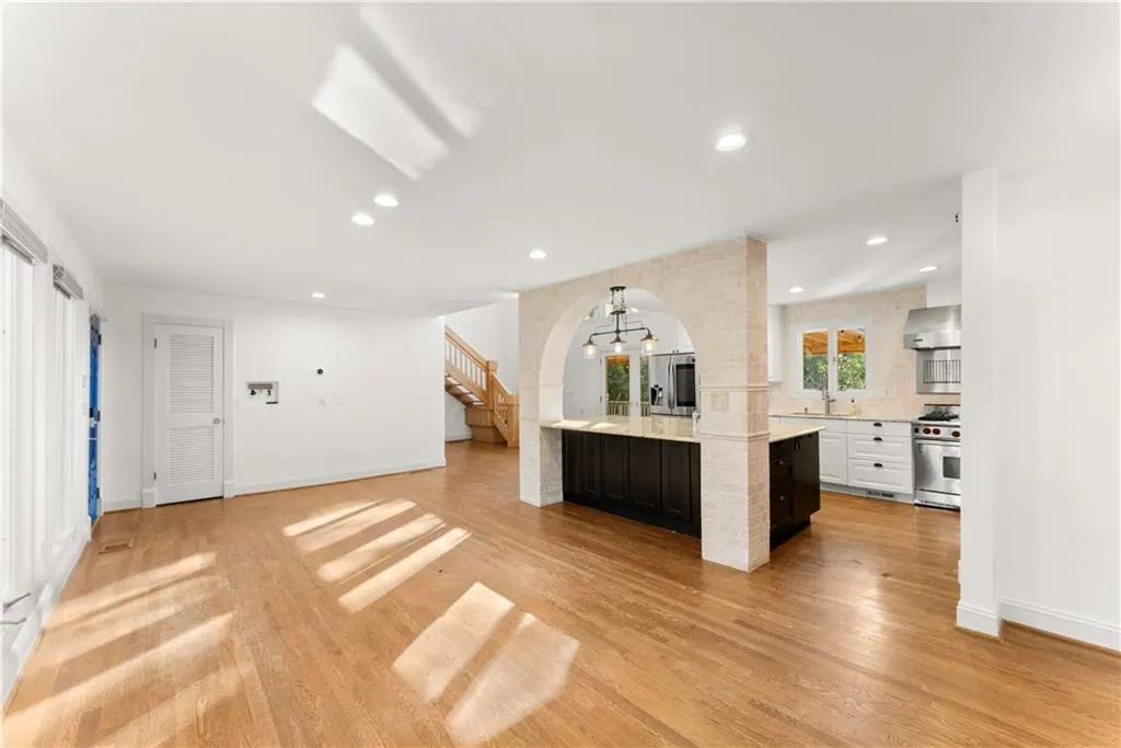 Kitchen with pendant lighting, recessed lighting, light stone countertops, light wood finished floors, and backsplash