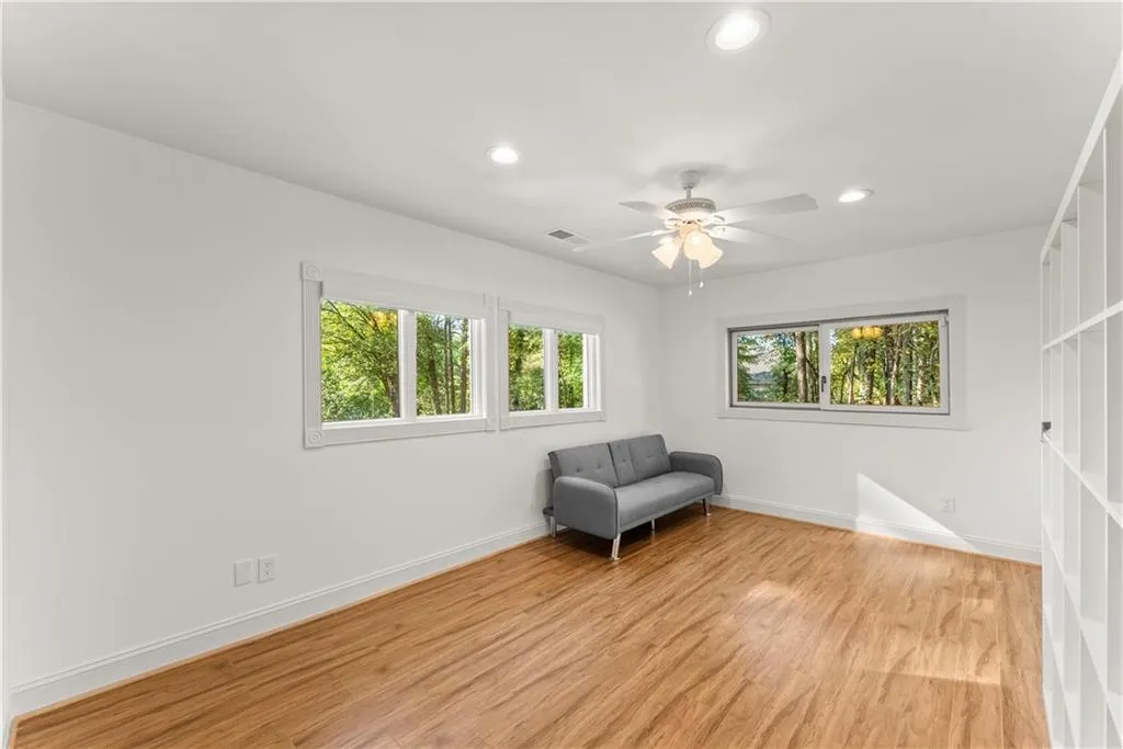 Living area featuring light wood-style floors, healthy amount of natural light, recessed lighting, and ceiling fan