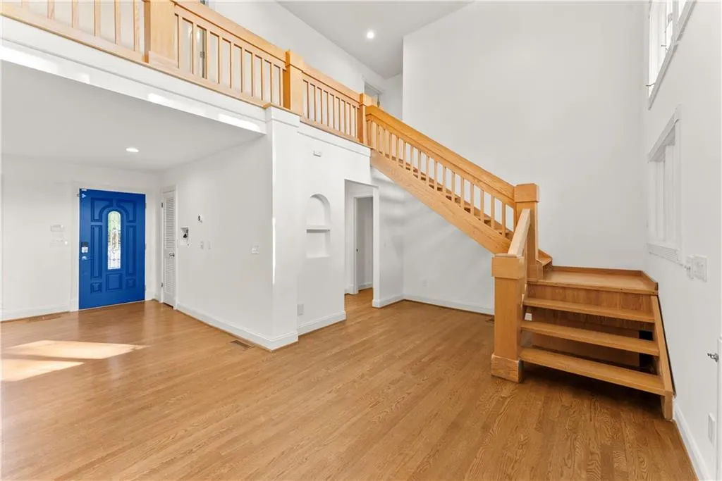 living room with stairway, light wood-type flooring, recessed lighting, and a high ceiling