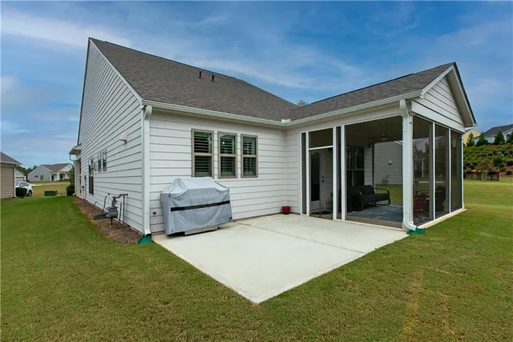 Screened porch with an adjacent concrete patio, white horizontal siding, and a gabled roofline