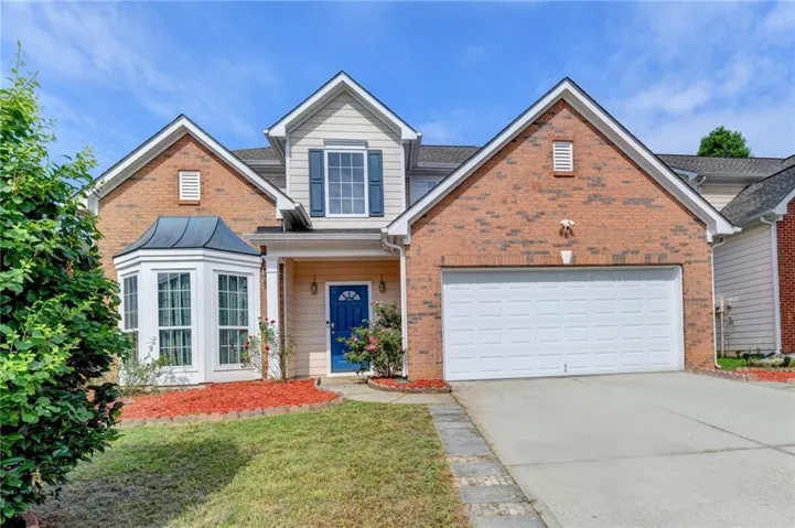 Brick and siding exterior featuring a prominent bay window with a curved metal roof accent