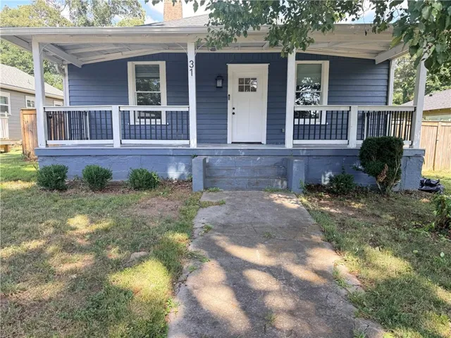 Blue siding exterior featuring a covered front porch with white columns and dark railings