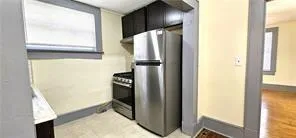 Kitchen with appliances with stainless steel finishes and dark cabinetry
