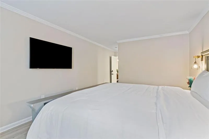 Bedroom with ornamental molding and light wood-style flooring Bedroom with ornamental molding and light wood-style flooring