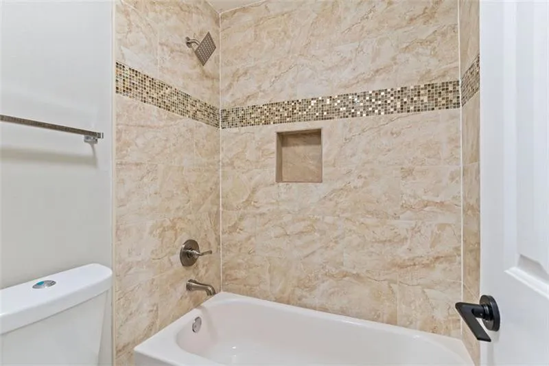 Bathroom featuring shower / bathtub combination and toilet Bathroom featuring shower / bathtub combination and toilet