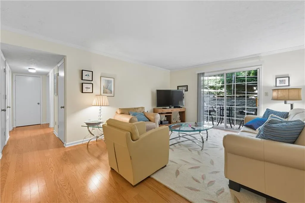 Living area featuring ornamental molding and light wood-style floors