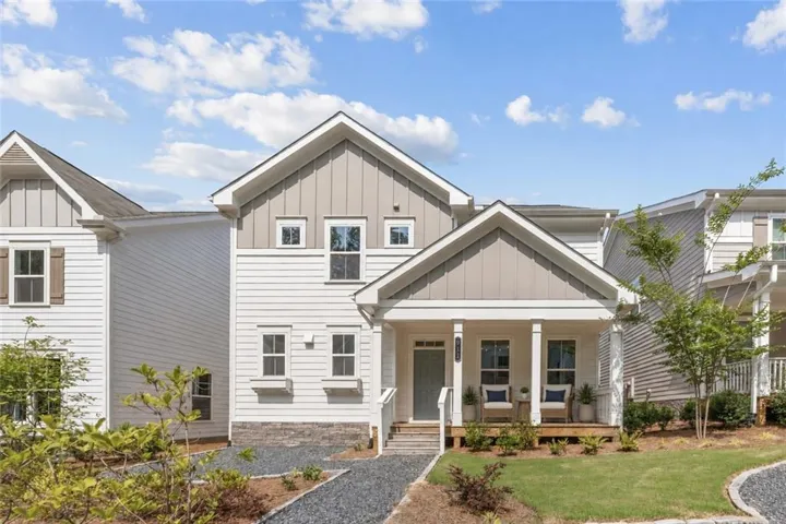 Two-story residence featuring white siding and gray gable accents