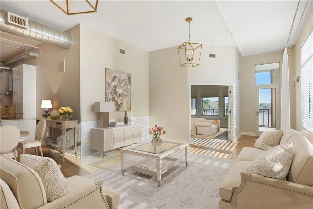 Living area with light wood finished floors, a high ceiling, and a chandelier