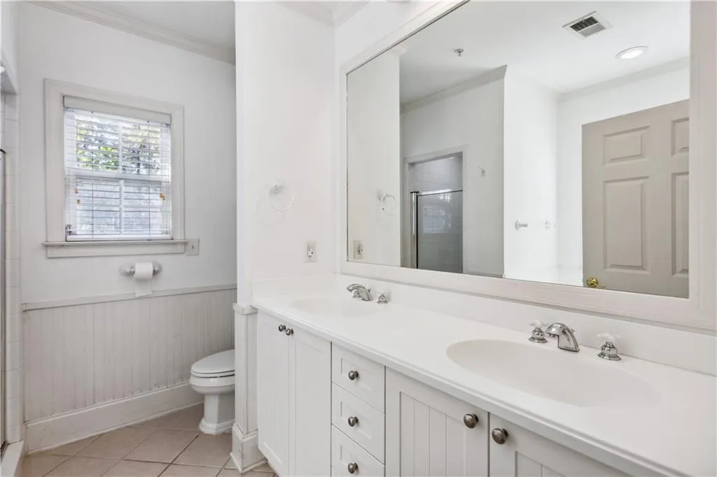 Bathroom featuring walk in shower, toilet, ornamental molding, vanity, and tile patterned flooring