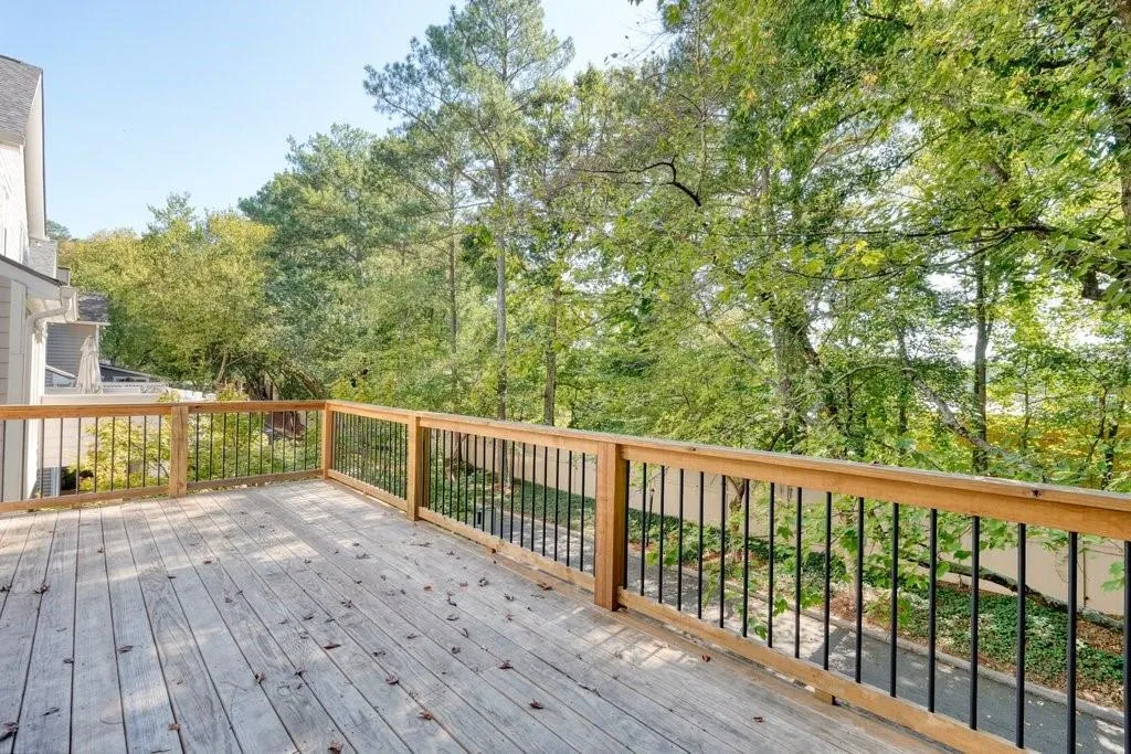Elevated wooden deck featuring wood-finish decking and black metal balusters